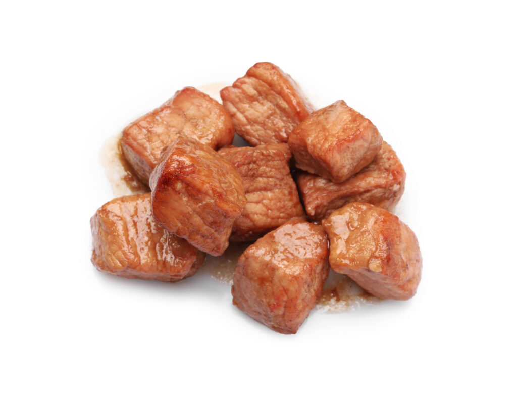 Pieces of delicious cooked beef isolated on white. Tasty goulash